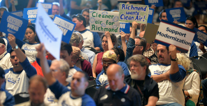 Some of the people attending the Richmond City Council's public comment meeting hold signs for and against Chevron's proposed refinery modernization project at the Richmond Auditorium in Richmond, Calif., on Tuesday, July 22, 2014. (Doug Duran/Bay Area News Group)